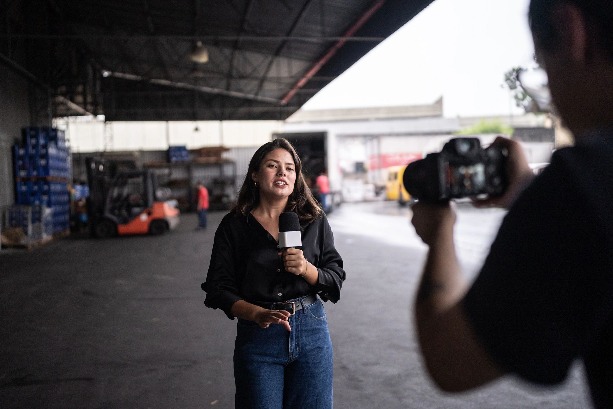 Reporter speaking on microphone to represent on-the-ground journalism