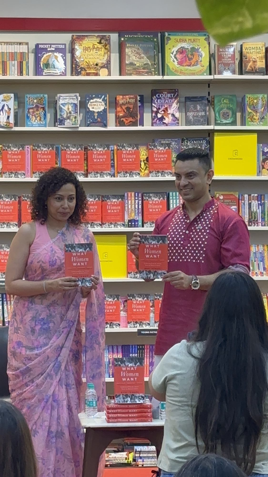 Author Ruhi Tewari in a pink saree and political analyst Tehseen Poonawalla in a maroon kurta holding copies of What Women Want at Crossword Pune.